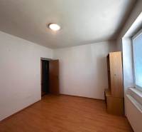 An empty room in a 3-room apartment with light furniture and a large window.