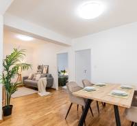 Dining table with four chairs, view into the living room in a three-room apartment.