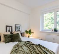 A bedroom with a window, a bed, and decorations in a 3-room apartment.