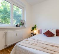 A bedroom in a 3-room apartment with a window, a bed, and decorations on the windowsill.