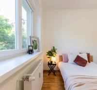 Bright bedroom in a 3-room apartment with a comfortable bed, decorations, and a large window.