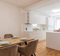 Dining table with place settings in the kitchen of a 3-room apartment with white furniture.