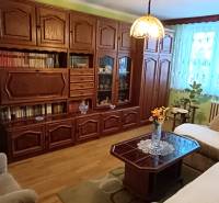 Living room with a sofa, display cabinet, and television in a three-room apartment.