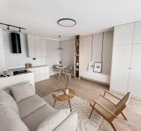 A bright interior with minimalist furniture, decorations, and wooden elements resembles a 2-room apartment.