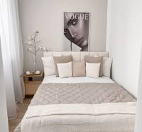 A bright, cozy bedroom in a 2-room apartment with a poster and decorative pillows.