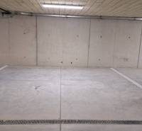 Parking space in an underground garage with concrete walls and floor.