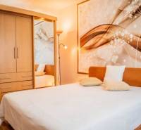 Cozy bedroom with a wooden wardrobe and a decorative wall in a studio apartment.