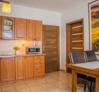 A kitchen in a studio apartment with wooden furniture and a dining table.