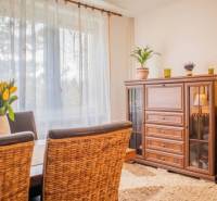Soft curtains and wooden furniture complement the cozy interior of the studio apartment.