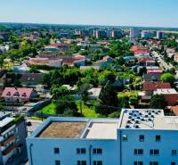 View of Bratislava-Podunajské Biskupice from Geologická, showing the surrounding houses and greenery.