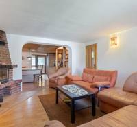 The interior of the cabin with a leather sofa, fireplace, and dining area.