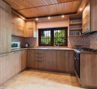 Wooden interior of a kitchen in a cottage with equipment and a window with a view of nature.
