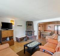 Living room with a fireplace, sofa, and television in a cottage, cozy rustic style.
