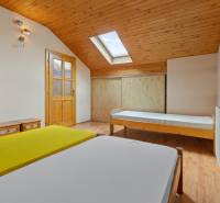 The interior of a cabin with wooden ceilings, beds, and a skylight.