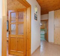 A cottage with wooden doors, tiles, a wooden ceiling, and paneling.