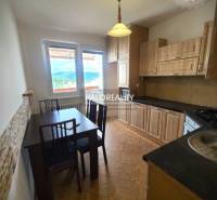 A kitchen in a 3-room apartment with a dining table and a view from the window.