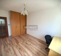 A room in a 3-room apartment with a wardrobe, a table, and a chair, light wooden floors.
