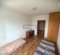 A room in a 3-room apartment with a bed, a wardrobe, and a desk on a wooden floor.