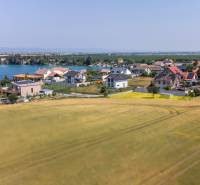 Plots - housing in Dunajská Lužná with a view of the lake, houses, and fields.