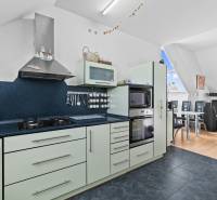 A kitchen in a family house with an oven, stove, and dining area.