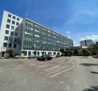 Office building on K výstavisku Street in Trenčín, parking lot with cars.