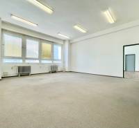 A bright room in offices with large windows and radiators.