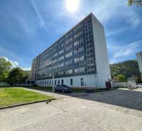 Offices on K výstavisku Street in Trenčín, next to it is a lawn and a parked car.