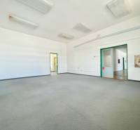 Spacious offices with a sink, bright lighting, and neutral colors.