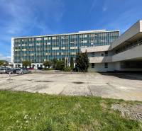 Office building on K výstavisku Street in the city of Trenčín with parking and greenery.
