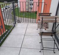 A balcony with a view of Jilemnického Street in the town of Svit; contains wooden furniture.