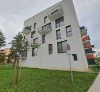 An apartment building on Jilemnického Street in Svit, surrounded by greenery and a walkway.