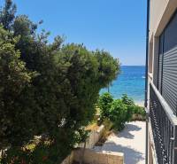 View from a 3-room apartment in Mandre to the sea, framed by greenery and tiles.