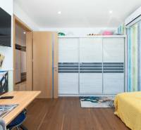 Interior of a family house with a built-in wardrobe, a desk, and colorful walls.