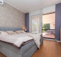 A bedroom in a family house with a bed and a view of the outdoor terrace.