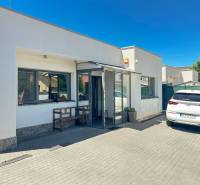 A family house in Senec with a white facade and a parking lot, a car parked in front of the entrance.