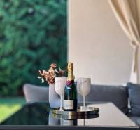 The exterior of a family house in Senec with a glass of champagne on the table on the terrace.