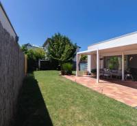 The grassy garden of a family house in Senec, terrace with seating and a grill.