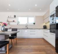 A kitchen in a family house with a wooden floor and modern furnishings, bright and spacious.