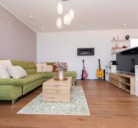 Living room with a green sofa and wooden floor in a family house.