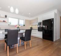 A spacious kitchen in a family house with wooden flooring and modern furnishings.