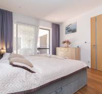 A bright bedroom in a family house with a large bed and wooden furniture.