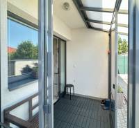 A glass veranda in a family house with garden elements and minimalist furniture.