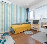 Children's room with a bed, desk, and air conditioning in a family house.