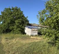 Lands - housing in the village of Povoda, green areas and trees under the blue sky.