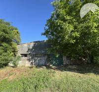 A plot in Povoda surrounded by trees with a shelter for living.