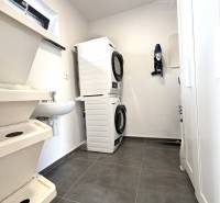 Laundry room in a family house with a washing machine and a washing area.