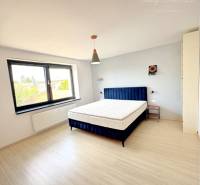 A bright room with a bed and large windows in a family house.