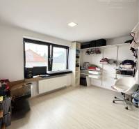 Room in a family house with storage shelves and a chair.
