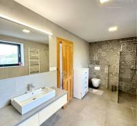 A bathroom in a family house with ceramic tiles and a shower corner.
