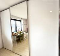 Built-in wardrobe with sliding doors and a mirror in a family house.